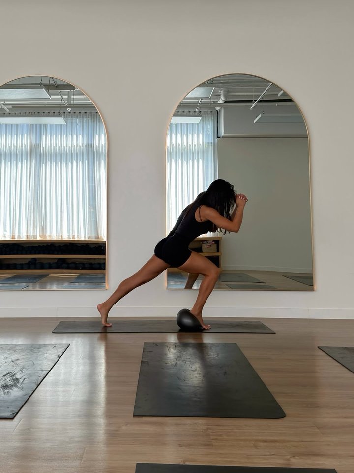 Follow-along Pilates sequence in a bright studio with arched windows
